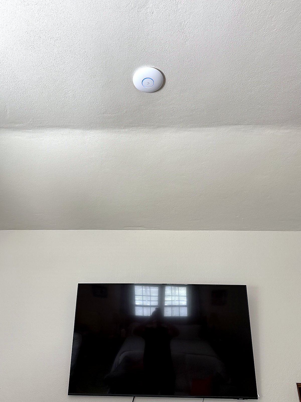 Ceiling access point above a wall-mounted TV