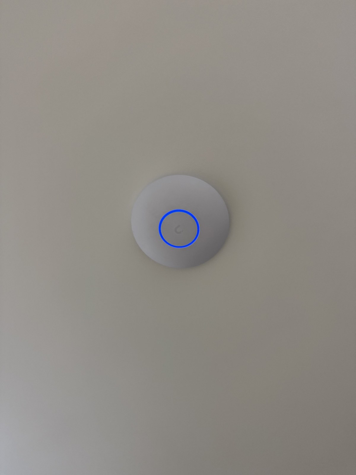 UniFi ceiling access point with active blue ring