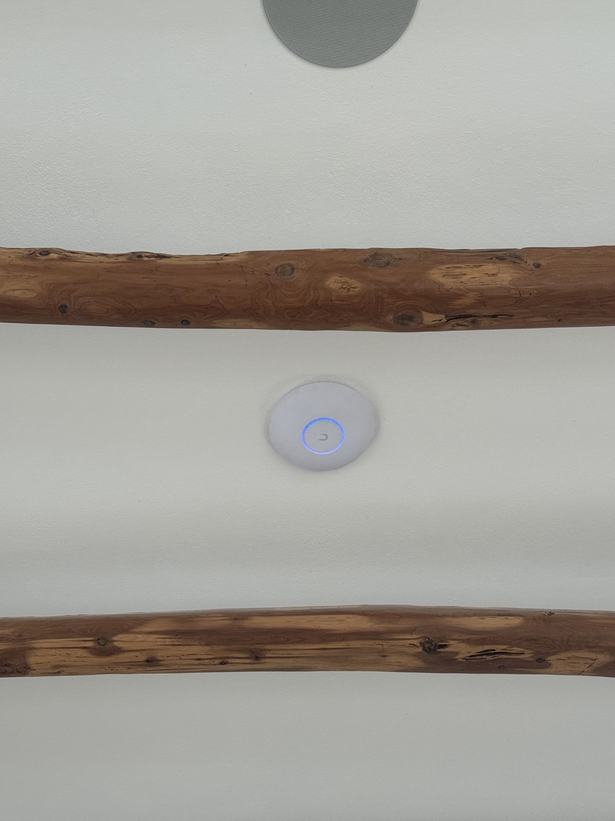 UniFi ceiling access point - between Bermuda's classic exposed wood beams
