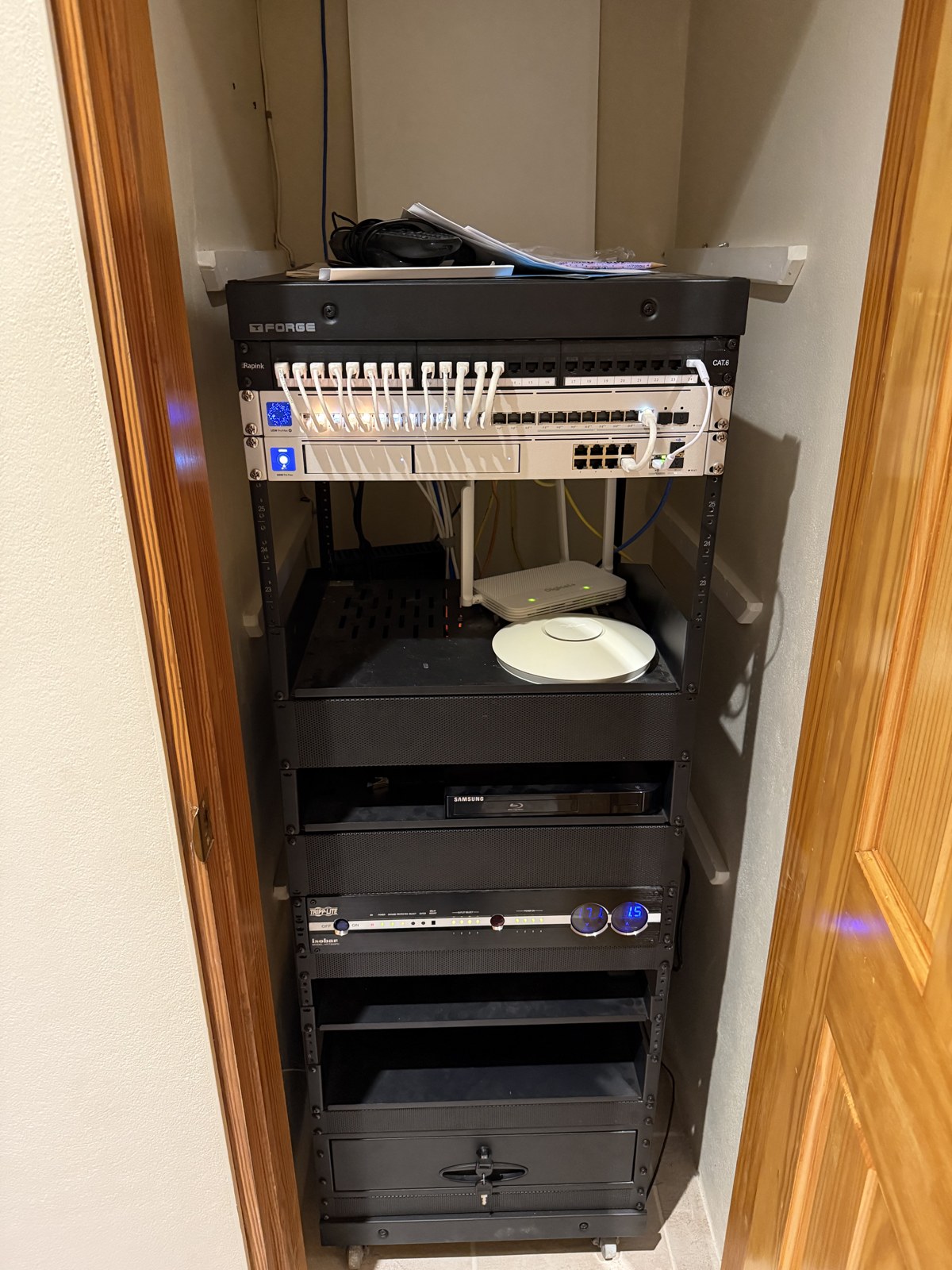 Full equipment rack - switch, patch panel and AV gear tucked in a closet