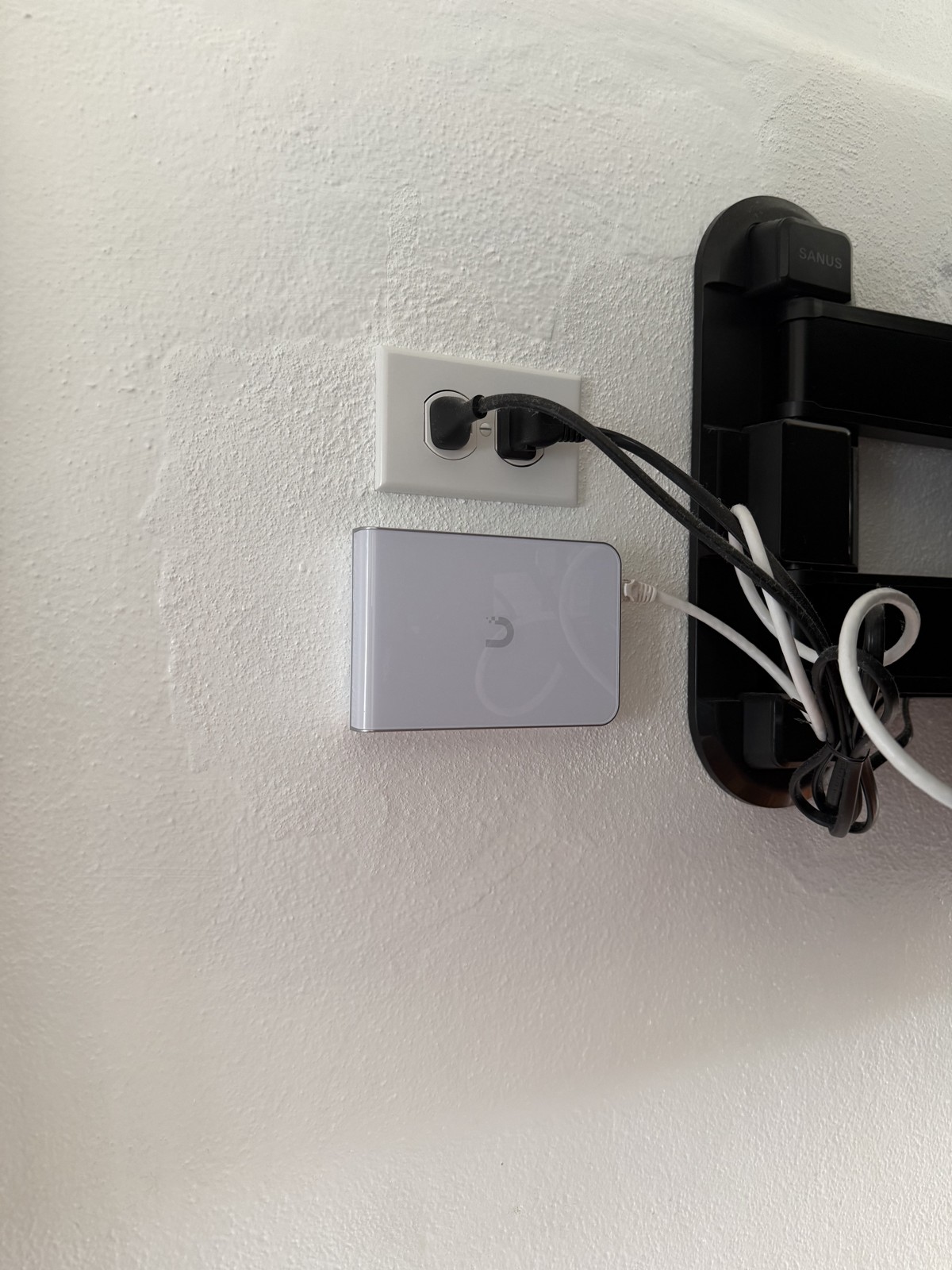UniFi Express gateway, cleanly wall-mounted beside the TV