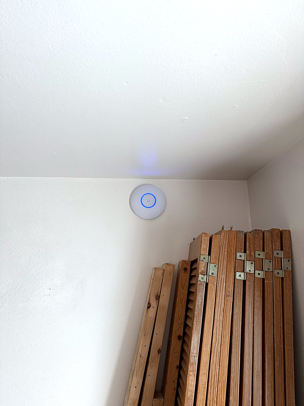 Wall-mounted UniFi access point with active blue ring
