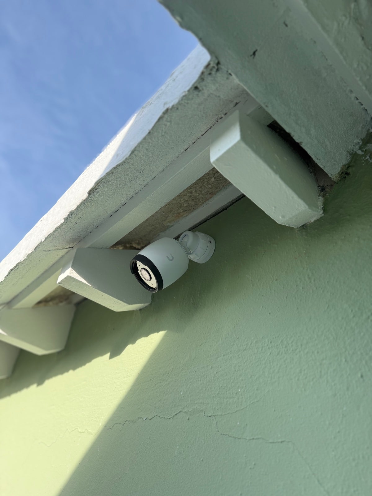Bullet camera placed under a green-painted eave