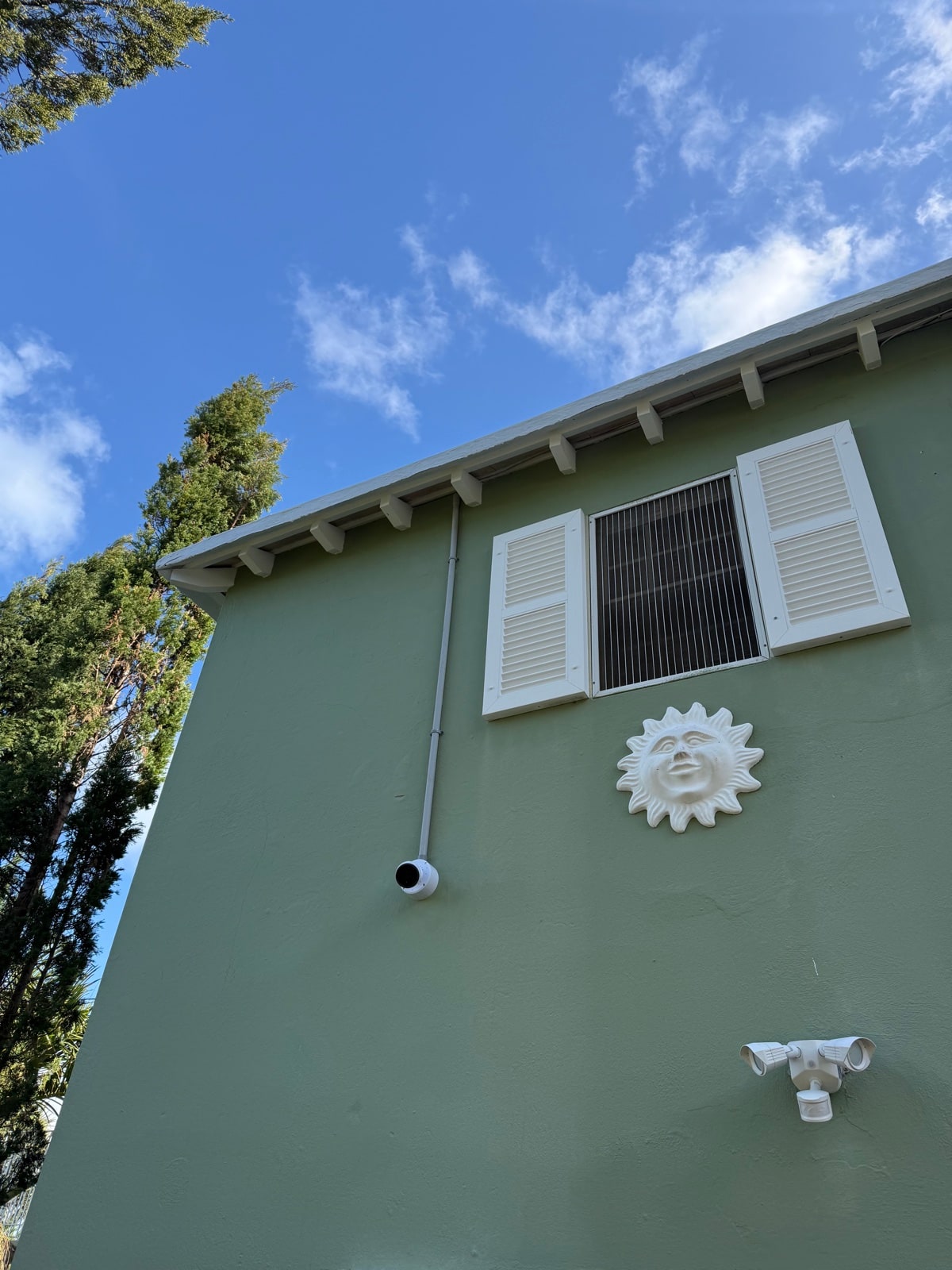 Discreet bullet camera on a Bermuda green-painted facade