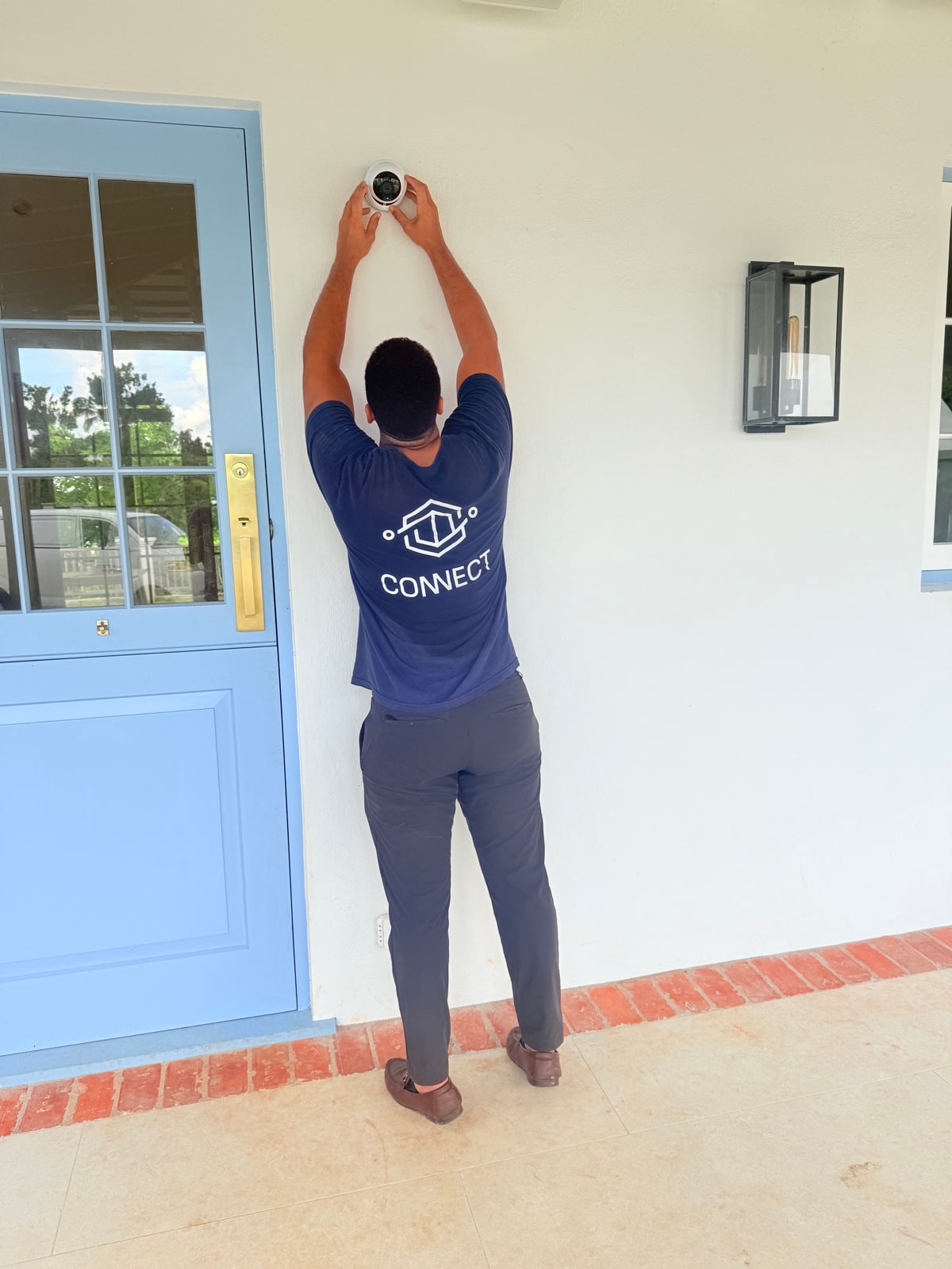 Connect installer mounting a camera over a front door