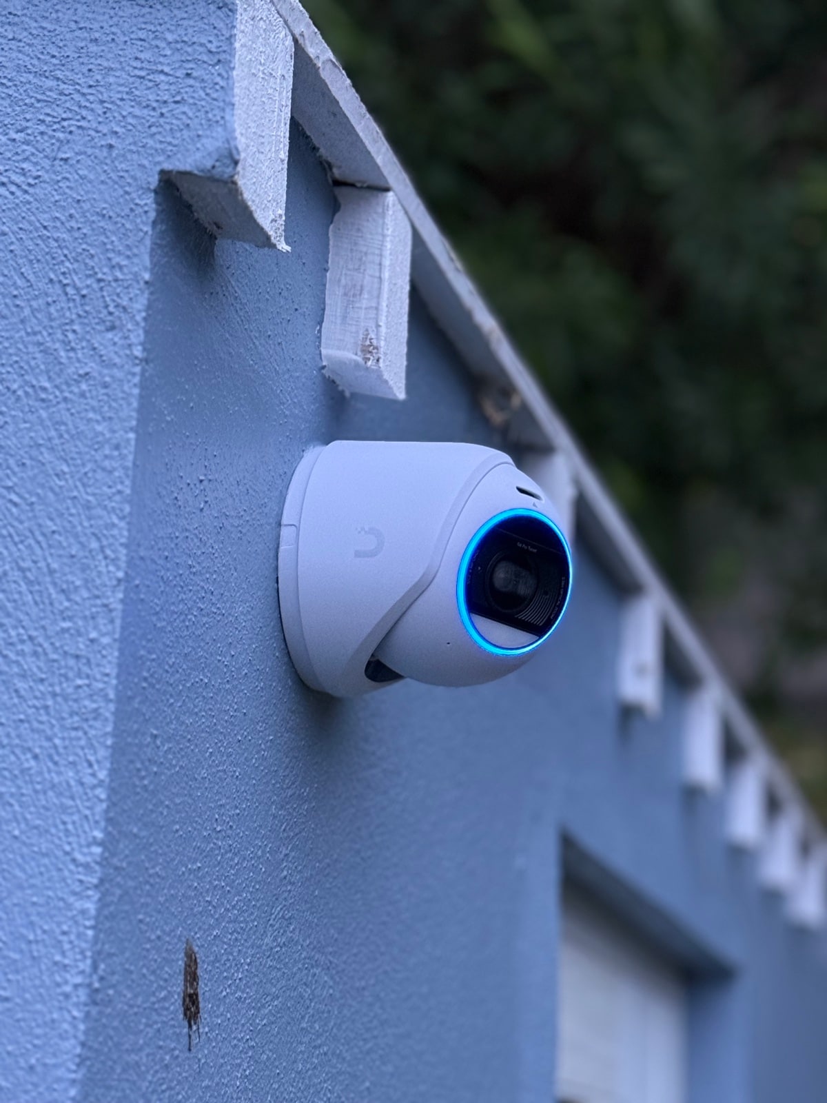 Turret camera with active blue ring on blue wall